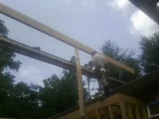 Carpenter setting a ridge beam over a new addition frame — Ice Dam Removal by Roofing Brothers in Kalispell