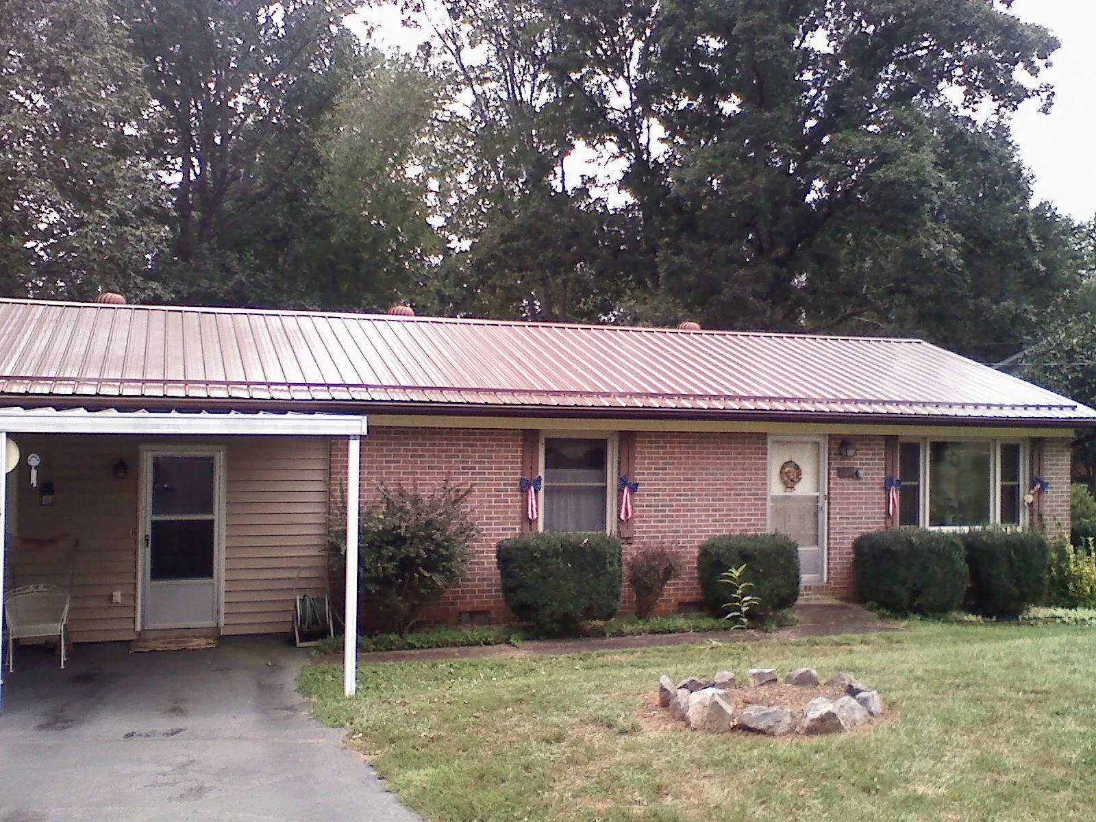Bronze metal roof and carport on a brick ranch home — Roof Repair work by our crew in Kalispell